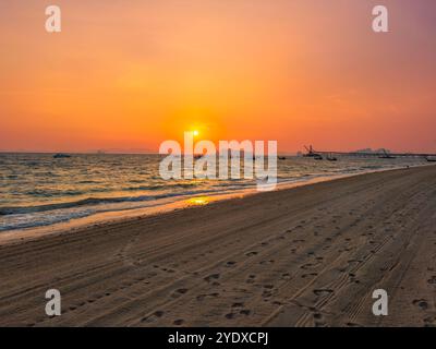 Feurig roter tropischer Sonnenuntergang am Strand Klong Muang in der Provinz Krabi in Thailand. Langschwanzboote im Meer. Stockfoto