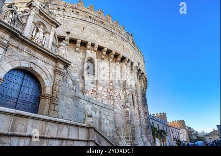Avila, Spanien - 11. Februar 2023: Eingangstür und äußere Steinmauer eines mittelalterlichen Domgebäudes. Stockfoto