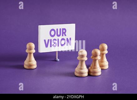 Schachfiguren stehen neben dem Banner mit der Botschaft unserer Vision. Ankündigung und Planung der Geschäftsvision. Stockfoto