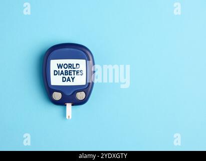 Gesundheitsfürsorge und Diabeteskonzept. Glukometer mit Weltdiabetestag auf dem Bildschirm. Stockfoto