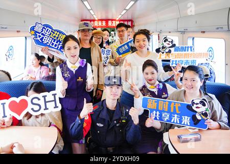 Shanghai. Oktober 2024. Passagiere und Besatzungsmitglieder posieren für ein Gruppenfoto während einer Werbeveranstaltung zur siebten China International Import Expo (CIIE) im Zug D3205 am 28. Oktober 2024. Die CIIE findet vom 5. Bis 10. November in Shanghai statt. Quelle: Xie Xin/Xinhua/Alamy Live News Stockfoto