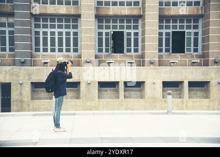 Asiatischer Tourist mit dslr professionelle Kamera reisen im Urlaub. Junge Reiterin mit Rucksack und Fotokamera in der Altstadt. Schöne Frau Stockfoto