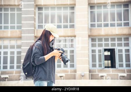 Asiatischer Tourist mit dslr professionelle Kamera reisen im Urlaub. Junge Reiterin mit Rucksack und Fotokamera in der Altstadt. Schöne Frau Stockfoto