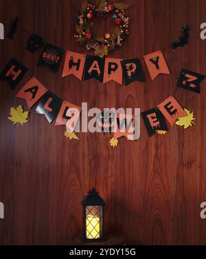 Frohes Halloween. Festlicher Hintergrund auf Holzwand mit Text für Grußkarte. Zusammensetzung mit Laterne. Stockfoto