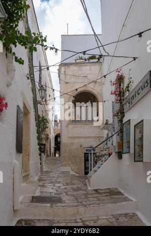 Ostuni Italien 18. September 2024 schlendern Sie durch die bezaubernden Straßen Apuliens, wo weiß getünchte Gebäude gesäumt von bunten Blumen eine malerische Atmosphäre schaffen. Stockfoto