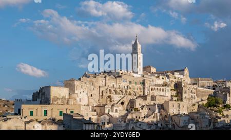 Matera liegt in den Hügeln von Apulien, Italien und zeigt seine alten Höhlenhäuser, die sich dramatisch gegen den Dämmerungshimmel erheben. Stockfoto