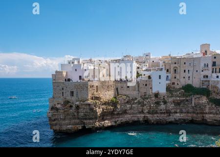 Polignano A Mare Italy der helle Sonnenschein beleuchtet die bezaubernden weißen Gebäude Apuliens, die sich dramatisch auf felsigen Klippen erheben. Stockfoto