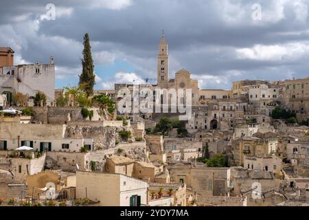Eingebettet in die Hügel von Apulien, zeigt Matera seine atemberaubende Steinarchitektur unter einem dynamischen Himmel. Die historischen Gebäude der Stadt bieten einen Einblick in ihr reiches Erbe und ihre lebendige Kultur. Stockfoto