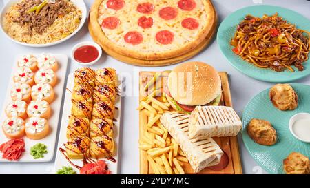 Verschiedene Gerichte - Pizza, Burger, Manti, Lagman, Döner, Sushi. Draufsicht auf hellem Hintergrund Stockfoto