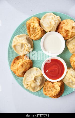 Manty mit Rindfleisch und Sauerrahm auf Holztisch Stockfoto