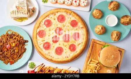 Verschiedene Gerichte - Pizza, Burger, Manti, Lagman, Döner, Sushi. Draufsicht auf hellem Hintergrund Stockfoto