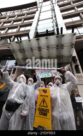 London, England, Großbritannien. Oktober 2024. Demonstranten in Gefahrgutanzügen, Masken und mit Tatortband protestieren vor den Büros der Allianz-Versicherungsgesellschaft. Extinction Rebellion (XR) spazieren Sie durch die City of London, halten Sie an und demonstrieren Sie vor den Büros von Versicherungsunternehmen, die trotz der Warnungen vor einer Klimakrise von Wissenschaftlern weiterhin Unternehmen für fossile Brennstoffe versichern. Die Demonstranten glauben, wenn die Versicherungsgesellschaften ihre Beteiligung an diesen Unternehmen beenden würden, würden sie es schwer tun, weiter zu bauen. Die Aktion ist die erste einer Woche lang, die sich speziell gegen t richtet Stockfoto