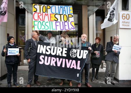 London, England, Großbritannien. Oktober 2024. Demonstranten protestieren vor den Büros der Allianz Versicherungsgesellschaft mit Schildern und einem Banner mit der Aufschrift "˜ versichern unser Überleben". Extinction Rebellion (XR) spazieren Sie durch die City of London, halten Sie an und demonstrieren Sie vor den Büros von Versicherungsunternehmen, die trotz der Warnungen vor einer Klimakrise von Wissenschaftlern weiterhin Unternehmen für fossile Brennstoffe versichern. Die Demonstranten glauben, wenn die Versicherungsgesellschaften ihre Beteiligung an diesen Unternehmen beenden würden, würden sie es schwer tun, weiter zu bauen. Die Aktion ist die erste von einer Woche lang Protestaktionen Stockfoto