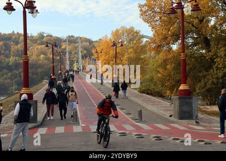 Nicht exklusiv: KIEW, UKRAINE - 27. OKTOBER 2024 - Menschen befinden sich an der Fußgängerbrücke, die die Insel Truchaniv mit dem rechten Ufer von Kiew, Capi, verbindet Stockfoto