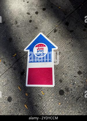 Pfeil auf dem Bürgersteig zeigt den Weg zu einem Wahlort für die Präsidentschaftswahlen 2024 in den Vereinigten Staaten von Amerika, New York City, NY, USA Stockfoto