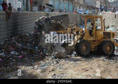 Infolge des anhaltenden Konflikts bedroht eine Umweltkatastrophe Millionen von Einwohnern im Jemen. Da die Stadtverwaltung geschlossen wurde und die Abfallsammelanlage in Taiz eingestellt wurde, sind die nicht gesammelten Abfälle durch sintflutartigen Regen in die Abwasseranlage gelangt. In jüngster Zeit wurden in den Krankenhäusern in Taiz zahlreiche Fälle von Cholera und Dengue-Fieber infolge der Verschlechterung der humanitären Lage in der Stadt verzeichnet. Manchmal haben Menschen in Taiz Planierraupen benutzt, um den Müll selbst zu entsorgen Stockfoto