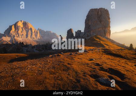 Das Sonnenaufgangslicht strahlt ein goldenes Licht über die Cinque Torri bei Cortina d'Ampezzo und beleuchtet die zerklüftete alpine Landschaft der italienischen Dolomiten. Stockfoto