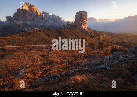 Das Sonnenaufgangslicht strahlt ein goldenes Licht über die Cinque Torri bei Cortina d'Ampezzo und beleuchtet die zerklüftete alpine Landschaft der italienischen Dolomiten. Stockfoto