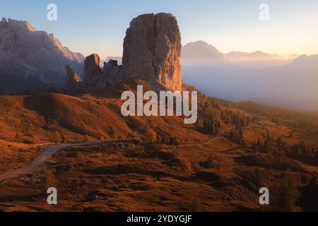 Das Sonnenaufgangslicht strahlt ein goldenes Licht über die Cinque Torri bei Cortina d'Ampezzo und beleuchtet die zerklüftete alpine Landschaft der italienischen Dolomiten. Stockfoto