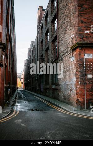 Verlassene urbane Gasse zwischen alten Backsteinhäusern. Stadtzentrum von Manchester, Großbritannien. Stockfoto