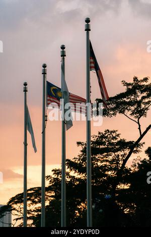 Mehrere malaysische Fahnen winken im Wind, mit einem wunderschönen Sonnenuntergang im Hintergrund. Stockfoto