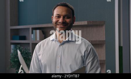 Geschäftsporträt im Büro Erwachsener indischer Mann amerikanischer Mann ethnischer Geschäftsmann Unternehmer Arbeitgeber mit Laptop posiert am Arbeitsplatz modernes Marketing Stockfoto