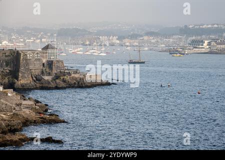 Ein traditioneller Segelkahn fährt entlang des Cattewater in Plymouth, Devon, vorbei an verankerten Segelyachten. Stockfoto