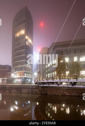 Moderne Appartements und Bürogebäude sind in einer Winternacht im schwimmenden Hafen von Bristol in Nebel gehüllt. Stockfoto