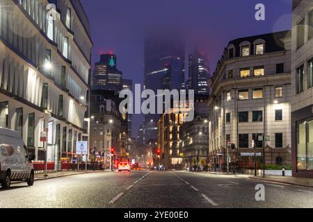 Wolkenkratzer des Geschäftsviertels der City of London erheben sich in einer Winternacht über der Queen Victoria Street. Stockfoto