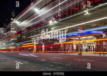 Der Verkehr hinterlässt nachts Lichtspuren vor der Aldgate Station in der City of London. Stockfoto
