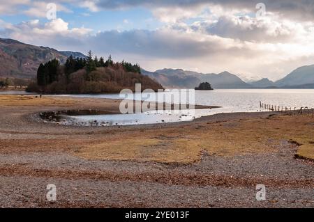 Schnee liegt auf den weit entfernten Bergen des Lake District, die aus Derwent Water in Cumbria aufsteigen. Stockfoto