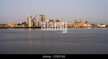 Der Mond erhebt sich hinter den Wohngebäuden der Liverpool Waters docklands, von der anderen Seite des Mersey aus gesehen. Stockfoto