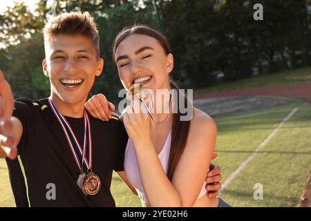 Porträt glücklicher Gewinner mit Medaillen im Stadion. Leerzeichen für Text Stockfoto