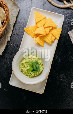 Klassische Guacamole mit knusprigen Tortilla-Chips, perfekt zum Naschen oder Teilen Stockfoto