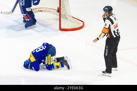 Kloten, Schweiz, 18. Oktober 2024: Chefschiedsrichter #91 Daniel Stricker unterbricht das Spiel. EHC Kloten Stürmer #88 Dario Meyer liegt verletzt auf dem Eis r Stockfoto