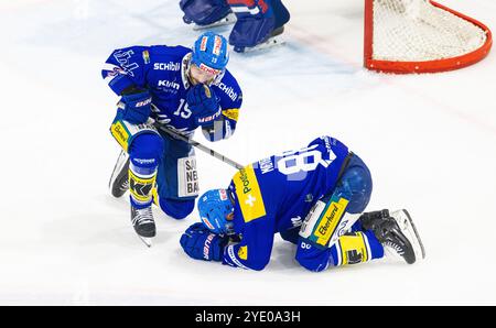 Kloten, Schweiz, 18. Oktober 2024: EHC Kloten Verteidiger und Mannschaftskapitän #19 Steve Kellenberger kümmert sich um #88 Dario Meyer, der verwundet liegt Stockfoto