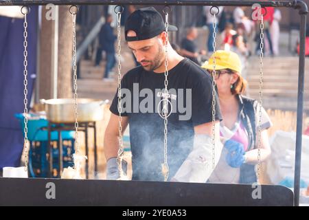 Ein italienischer Mann schneidet ein Stück Caciocavallo, einen typischen geräucherten Käse aus Süditalien in Melfi, Basilicata - Italien Stockfoto