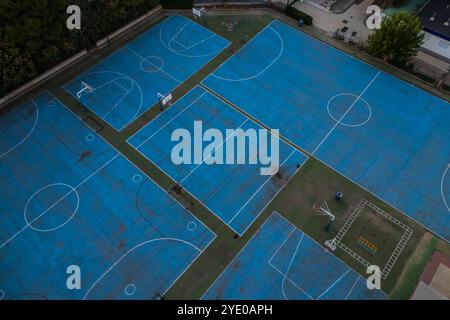 Blick aus der Vogelperspektive auf blaue Basketball- und Sportplätze auf dem Schulspielplatz Stockfoto