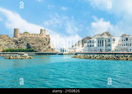 Blick auf die arabische Al Jalali Burg auf den Felsen und weiße königliche Palastgebäude, Muscat, Oman Stockfoto