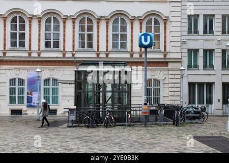 Wien, Österreich - 4. Oktober 2024: Frau neben dem Eingang der Wiener U-Bahn mit Fahrrädern und Abfalleimer, mit Glasaufzug Stockfoto