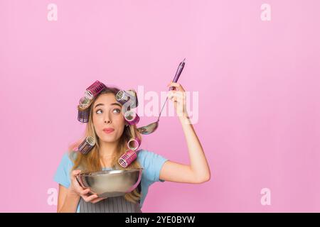 Multitasking Hausfrau zu Hause Verkostung aus Schüssel Stockfoto