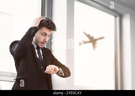 Junger Geschäftsmann, der auf Armbanduhr im Auto schaut Stockfoto