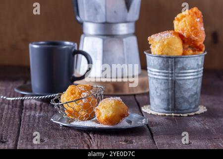 Quark Donuts mit Zucker serviert mit Tee oder Kaffee auf hellem Holzhintergrund. Rustikaler Stil, selektiver Fokus. Stockfoto