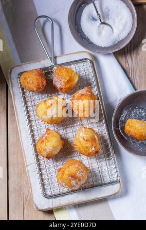 Quark Donuts mit Zucker serviert mit Tee oder Kaffee auf hellem Holzhintergrund. Rustikaler Stil, selektiver Fokus. Stockfoto