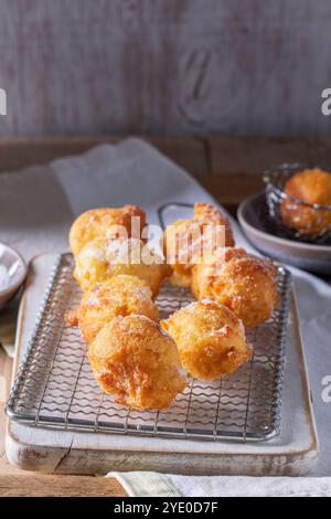 Quark Donuts mit Zucker serviert mit Tee oder Kaffee auf hellem Holzhintergrund. Rustikaler Stil, selektiver Fokus. Stockfoto