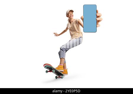 Glückliche junge Frau, die ein Longboard fährt und ein Smartphone auf weißem Hintergrund zeigt Stockfoto