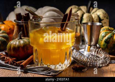 Hausgemachter alkoholischer Kürbis-Zimt-Cocktail, erfrischender eisgekühlter Kürbis-Gewürz-altmodischer Cocktail, Holzküchentisch im Hintergrund Kopierraum Stockfoto