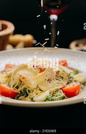 Eleganter Caesar-Salat mit gegrilltem Huhn, Parmesan, Kirschtomaten und gekochten Wachteleiern Stockfoto