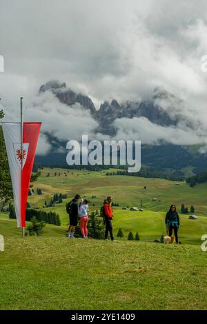 Wanderer unter Tiroler Flagge in einem Almgasthof (Restaurant) auf der Seiser Alm (Seiser Alm), der größten Hochalpenwiese Europas, UNESCO W Stockfoto