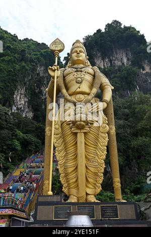 Nahaufnahme der 140 m hohen Lord Murugan Statue am Fuße der Batu Caves, mit Blick auf die Karstkalksteinhügel im Hintergrund Stockfoto